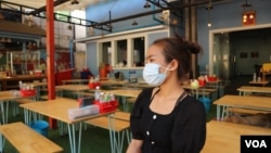 Channa Sokhim, a local food store owner, sits at her shop with empty tables in Phnom Penh, Cambodia, March 26, 2020. (Kann Vicheika/VOA Khmer) 