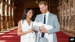 Britain's Prince Harry and Meghan, Duchess of Sussex, during a photocall with their newborn son, in St George's Hall at Windsor Castle, Windsor, south England, May 8, 2019. 