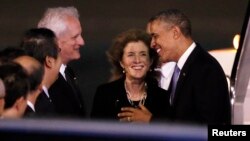 El presidente Barack Obama es recibido en Tokio por la embajadora Caroline Kennedy y su esposo, Edwin Schlossberg y otros funcionarios japoneses.