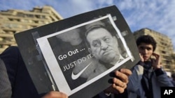 A protester holds a placard showing Egyptian President Hosni Mubarak and reading "Go out... Just do it" at the continuing anti-government demonstration in Tahrir Square in downtown Cairo, Egypt, February 10, 2011.