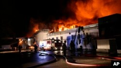 In this photo provided by the Russian Emergency Situations Ministry press service, firefighters work at the scene of a large blaze at a plastic warehouse in Moscow, Russia, Sept. 23, 2016.