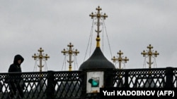 Seorang perempuan berjalan di jembatan dekat sebuah gereja di Moskow pada 2 Maret 2021. (Foto: AFP/Yuri Kadobnov)