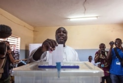 FILE - Burkina Faso presidential candidate from the UPC party Zephirin Diabre, center, casts his ballot during elections in Ouagadougou, Burkina Faso, Nov. 29, 2015.