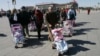 FILE - Spanish couples take their newly adopted Chinese children for a walk in Beijing's Tiananmen Square, March 7, 2007. The Chinese government is ending its intercountry adoption program.