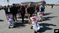 FILE - Spanish couples take their newly adopted Chinese children for a walk in Beijing's Tiananmen Square, March 7, 2007. The Chinese government is ending its intercountry adoption program.