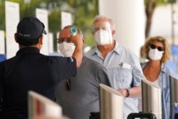 Florida seniors have their temperatures taken before receiving the second dose of the Pfizer COVID-19 vaccine at Jackson Health System, in Miami, Feb. 8, 2021.