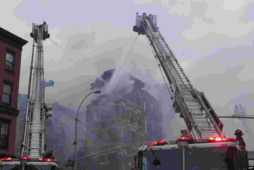 New York firefighters battle a blaze at a commercial and residential block on March 26, 2015, in New York&#39;s East Village. The entire building at 125 Second Avenue was engulfed in flames and the lower two floors appeared partially collapsed, television footage and press photographs showed. Twelve people were reported hurt.