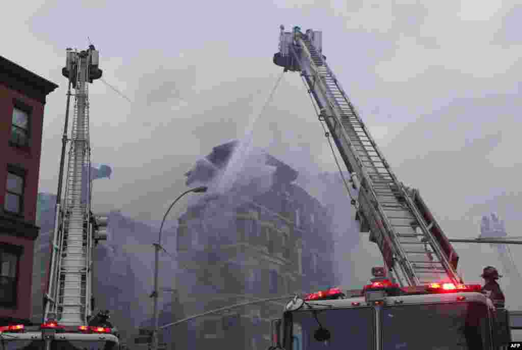 New York firefighters battle a blaze at a commercial and residential block on March 26, 2015, in New York's East Village. The entire building at 125 Second Avenue was engulfed in flames and the lower two floors appeared partially collapsed, television footage and press photographs showed. Twelve people were reported hurt.