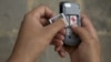 A mobile phone user in Juba, South Sudan removes his battery to check his SIM card. The government has ordered all SIM cards to be registered by February 28, citing security reasons.