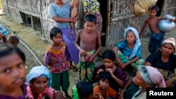 Rohingya Muslims pass time near their shelter at a refugee camp outside Sittwe, Myanmar.