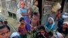 FILE - Rohingya Muslims pass time near their shelter at a refugee camp outside Sittwe, Myanmar, June 2014.