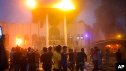Para demonstran menyerang dan membakar konsulat Iran di kota Basra, Irak, Jumat (7/9). 
