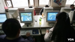 FILE - Users work at computers at an internet cafe in Beijing, Feb. 8, 2007. China remains the world's largest online piracy market.