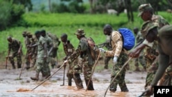 Kenya Defense Force (KDF) soldiers patrol and inspect through mud and debris on May 11, 2018 in search of bodies of victims after a dam burst its banks in Subukia, Nakuru county. 