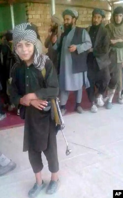 A young Islamic State fighter poses for a journalist after he surrendered to government security forces in the Darzab district of Jawzjan province, north of Kabul, Afghanistan, Aug. 1, 2018.