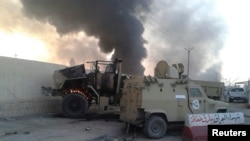 Musul'daki çatışmalarda ateşe verilen bir Irak zırhlı aracı 