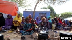 FILE - Somali families, displaced after fleeing the Lower Shabelle region amid an uptick in U.S. airstrikes, sit under a tree at an IDP camp near Mogadishu, Somalia, March 12, 2020. 