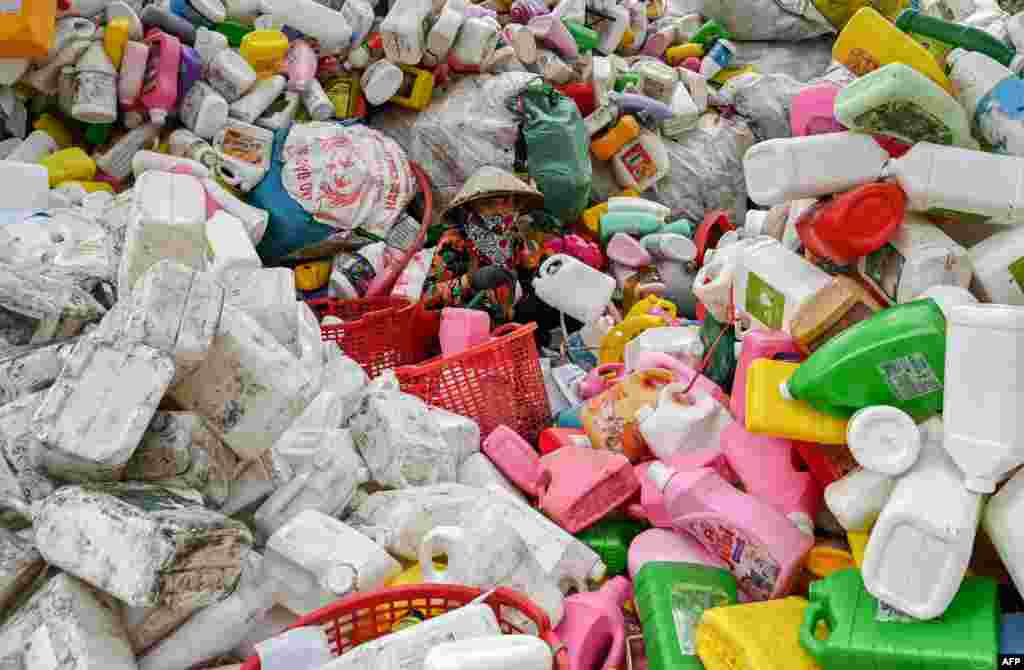 Seorang pekerja perempuan memilah-milah sampah plastik di lokasi daur ulang di pinggiran ibu kota Hanoi, Vietnam. (AFP)&nbsp;