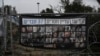 A poster shows pictures of the Bibas family, top row from second left: Yarden, Shiri, and their sons Ariel and Kfir, who were kidnapped on Oct. 7, 2023, in Jerusalem, Feb. 21, 2025. Words above read, '37 members of Kibbutz Nir Oz are still missing.'