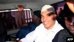 Karim Wade, fils de l'ancien président Abdoulaye Wade (2000-2012), arrive au tribunal entouré d’agents de sécurité à bord d’un véhicule, à Dakar, Sénégal, 31 juillet 2014.