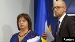 FILE - Ukraine's Prime Minister Arseny Yatseniuk and Finance Minister Natalia Yaresko leave a news conference in Kyiv, Ukraine, Oct. 15, 2015.