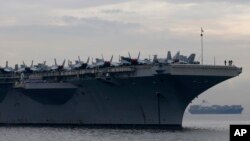 Sailors and fighter jets are seen on the deck of the U.S. aircraft carrier USS Ronald Reagan (CVN 76) as it anchors off Manila Bay for a goodwill visit, June 26, 2018, west of Manila, Philippines. 