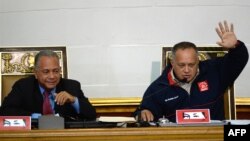 El presidente de la Asamblea Nacional de Venezuela, Diosdado Cabello (D), levanta la mano junto al vicepresidente Elvis Amoroso (I), durante una sesión de la Asamblea Nacional,