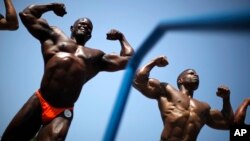 Men compete in the Muscle Beach Independence Day bodybuilding contest on Venice Beach in Los Angeles, California, July 4, 2013. REUTERS/Lucy Nicholson (UNITED STATES - Tags: SOCIETY SPORT) - RTX11CYF