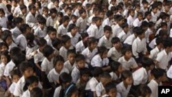 Cambodian school children sit under the shade of tree as they listen to teacher at Trapaing Loeuk primary school in Kampong Speu province.