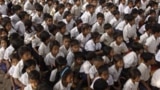 Cambodian school children sit under the shade of tree as they listen to teacher at Trapaing Loeuk primary school in Kampong Speu province.