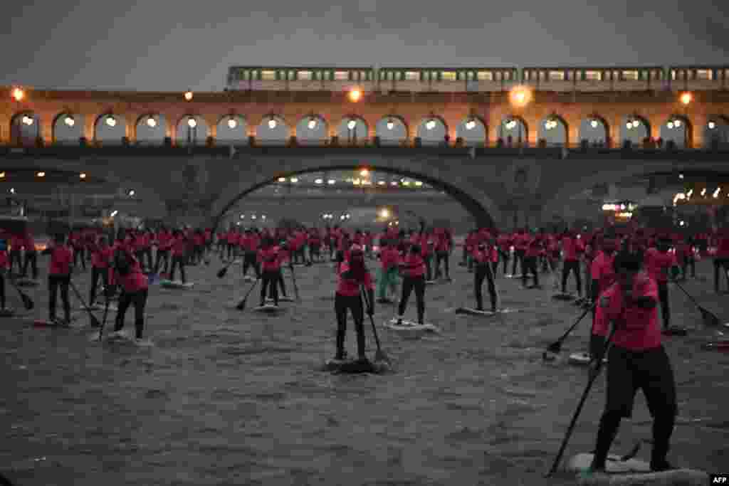 Amateurs and professionals take part in the Nautic Sup Paris crossing stand up paddle race along the Seine River in Paris, France.