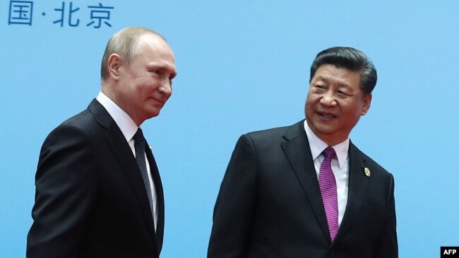 China's President Xi Jinping, right, and Russia's President Vladimir Putin smile during the welcoming ceremony on the final day of the Belt and Road Forum in Beijing, April 27, 2019.
