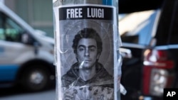 Sebuah poster yang berisi wajah Luigi Mangione terpasang di luar di hotel New York Hilton Midtown di New York, pada 12 Desember 2024. (Foto: AP/Julia Demaree Nikhinson)