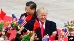 Presiden AS Donald Trump (kanan) dan Presiden China Xi Jinping disambut oleh anak-anak yang melambaikan bunga dan bendera saat upacara penyambutan di Aula Besar Rakyat di Beijing, 9 November 2017.