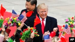 U.S. President Donald Trump, right, and Chinese President Xi Jinping are greeted by children waving flowers and flags during a welcome ceremony at the Great Hall of the People in Beijing, Nov. 9, 2017. 