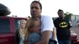 Judy Goos, second from left, hugs her daughter's friend, Isaiah Bow, 20, while eye witnesses Emma Goos, 19, left, and Terrell Wallin, 20, right, gather outside Gateway High School where witnesses were brought for questioning July 20, 2012 in Denver.
