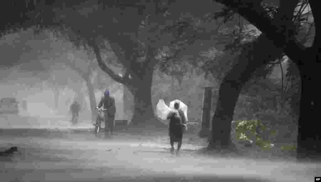 A man covers himself with a plastic sheet near Gopalpur junction in Ganjam district, about 200 kilometers from the eastern Indian city Bhubaneswar, Oct. 12, 2013.