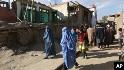 Beberapa perempuan Afghanistan berjalan melewati rumah-rumah yang hancur akibat gempa diKabul, Afghanistan (26/10).