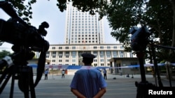FILE - A policeman guards the entrance of the Jinan Intermediate People's Court in Jinan, Shandong province, Aug. 26, 2013. 