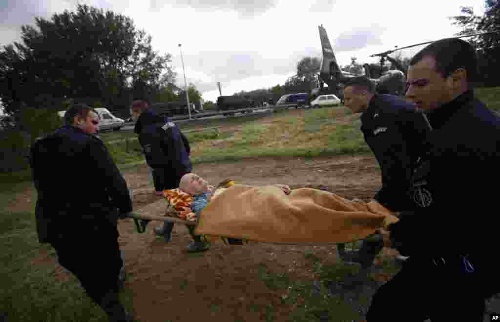 Polisi menggotong seorang pria dari helikopter militer dalam evakuasi banjir di Obrenovac, Serbia (17/5).&nbsp;(AP/Darko Vojinovic)