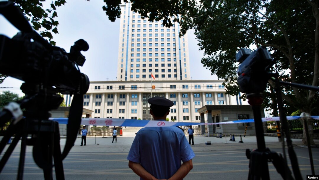 FILE - A policeman guards the entrance of the Jinan Intermediate People's Court in Jinan, Shandong province, Aug. 26, 2013. 