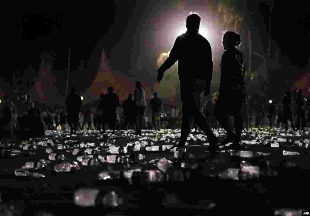 April 18: Music fans walk through water bottles towards the exit at the end of the Coachella Music & Arts Festival, early Monday morning in Indio, Calif. (AP Photo/Spencer Weiner)