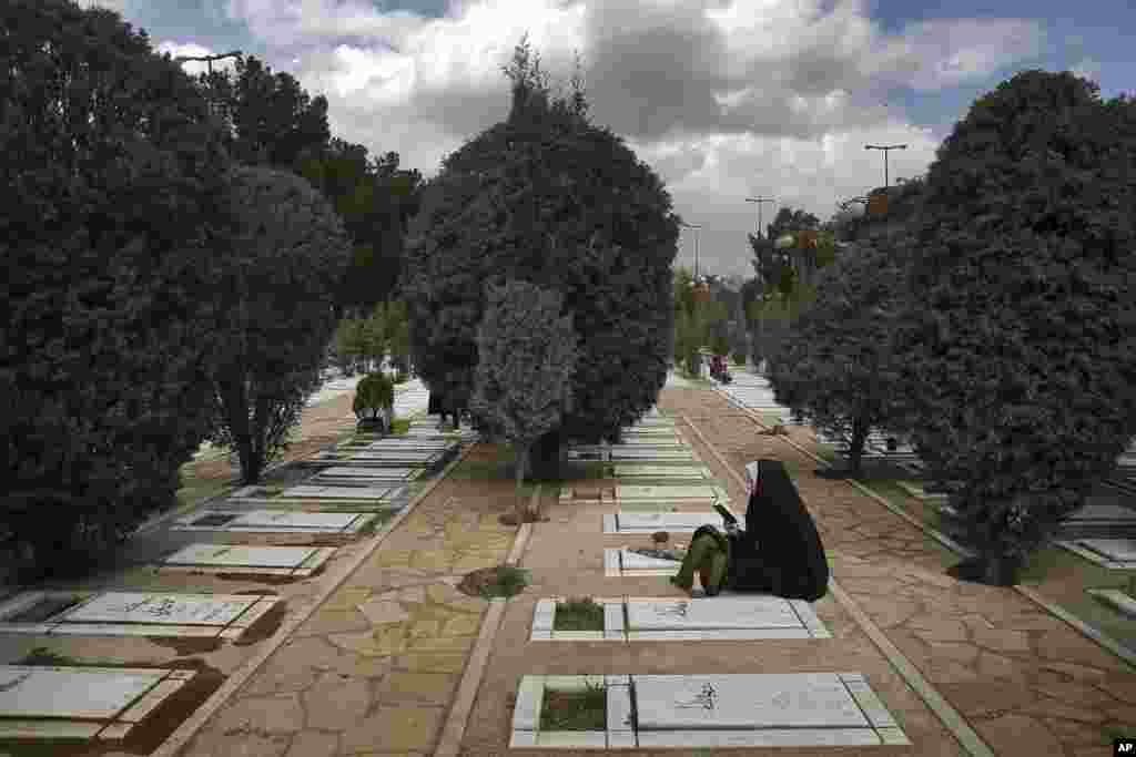 İranlı qadın İran-İraq müharibəsində həlak olmuş əzizinin məzarını ziyarət edir. Beheşt-e-Zəhra qəbiristanlığı. Tehran.