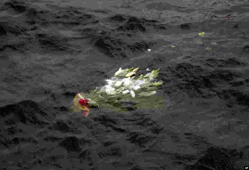 Flowers laid by relatives of the 32 victims of the Costa Concordia cruise shipwreck float on the sea off the Tuscan Island of Isola del Giglio, Italy, to mark the first anniversary of the grounding.