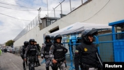 Policías y soldados se preparan para ingresar a la prisión El Inca donde se registran disturbios, en Quito, Ecuador, el 8 de enero de 2024.