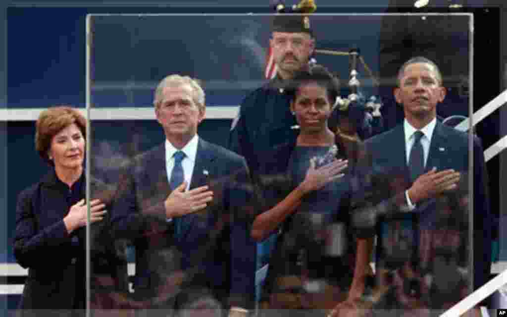 Former first lady Laura Bush, from left, former President George W. Bush, first lady Michelle Obama and President Barack Obama hold hands to their hearts during the national anthem as friends and relatives of the victims of 9/11 gather for a ceremony mark