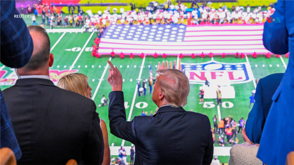 O Presidente dos EUA, Donald Trump, acena enquanto o hino nacional é tocado antes do início do Super Bowl de 2025.