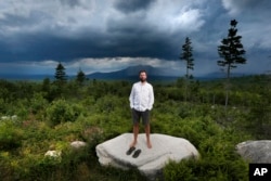 FILE - Lucas St. Clair, the son of Burt's Bees founder Roxanne Quimby, poses on land proposed for a national park in Penobscot County, Maine, Aug. 4, 2015.