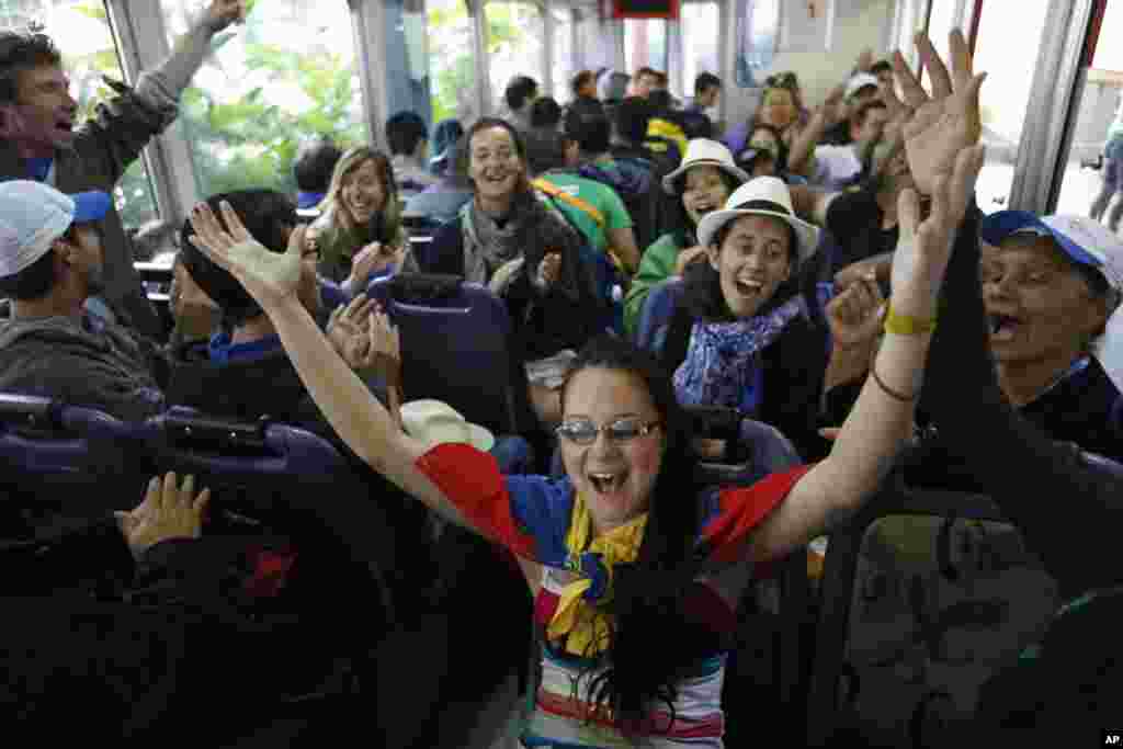 Para pemuda dari Perancis, Venezuela dan Kanada yang ada di Brazil untuk Hari Pemuda Sedunia bernyanyi saat mengendarai kereta yang membawa mereka ke gunung Corcovado, tempat patung Kristus Penebus berdiri di Rio de Janeiro, Brazil (23/7).&nbsp;(AP/Jorge Saenz)