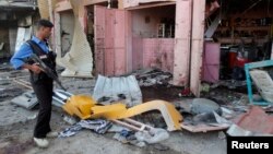 A police officer inspects the site of a bomb attack in Kirkuk, May 25, 2014. 